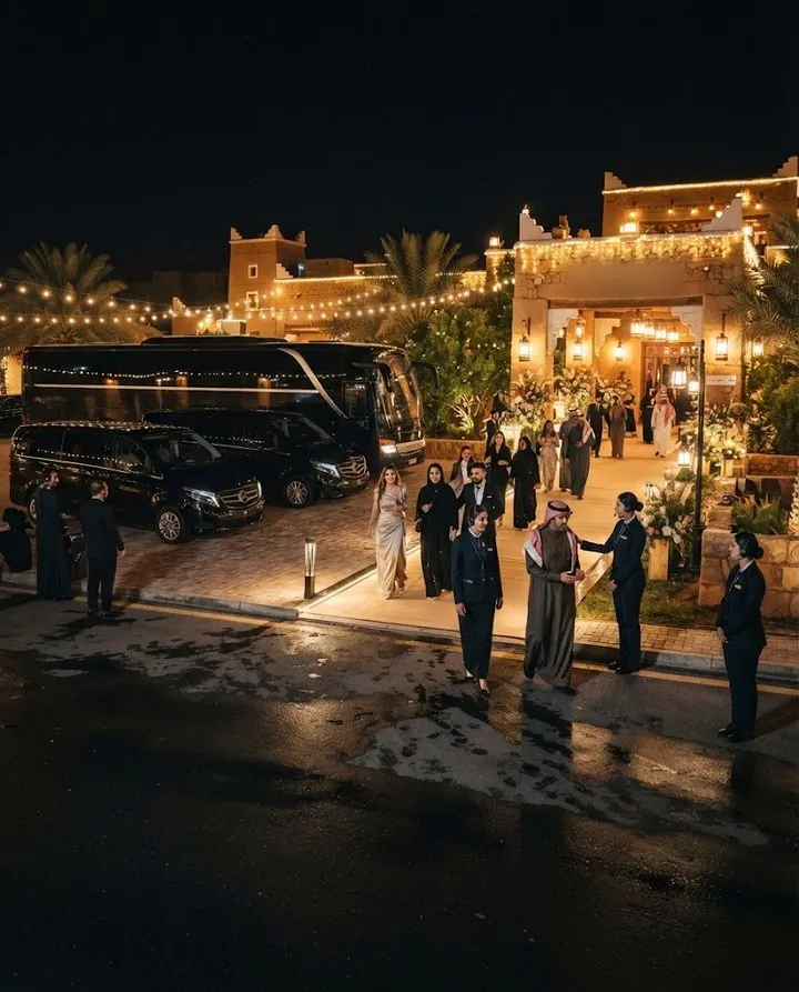 Guests arriving at an evening event with vans and a coach